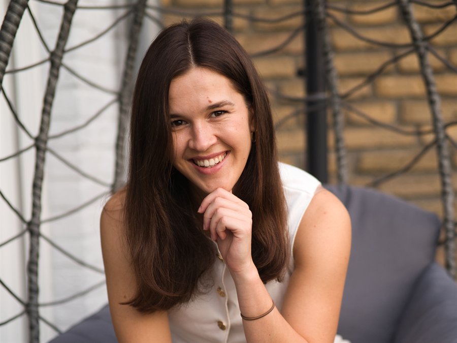 Leonie stützt lachend das Kinn auf die Hand