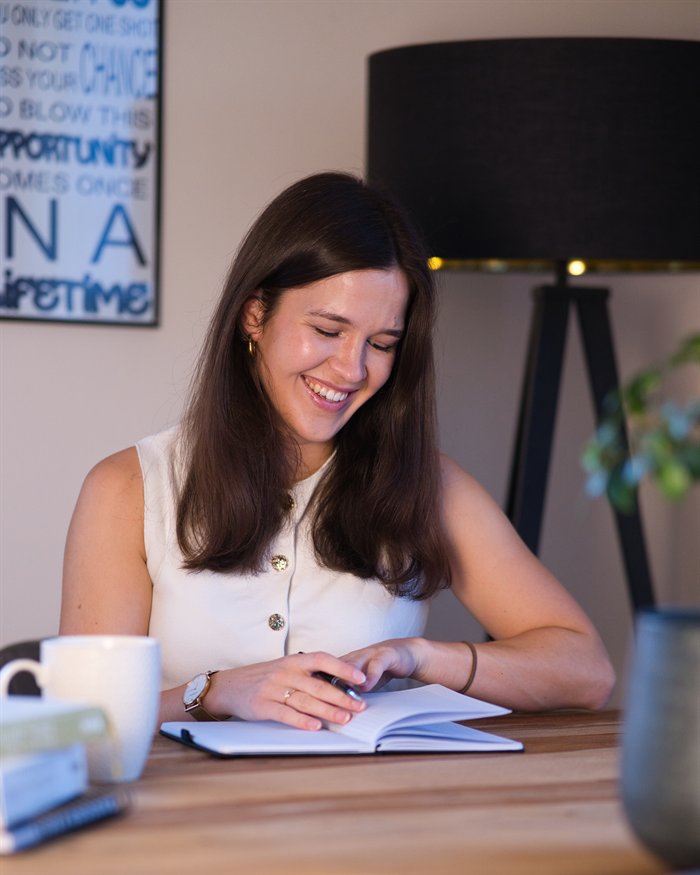 Leonie blättert lächelnd in ihrem Journal