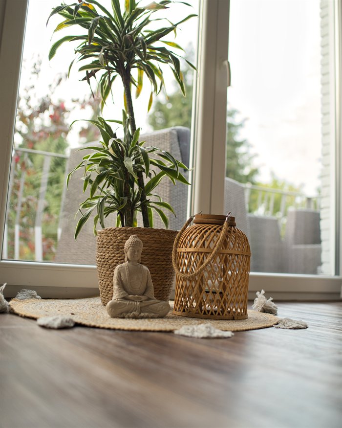 Dekoration mit Pflanze, Laterne und Buddha-Figur am Fenster